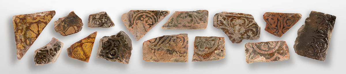 Fragments of Medieval tiles from Butley Priory, showing intricate floral designs.